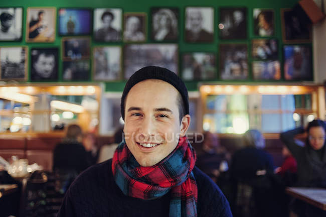Uomo sorridente al pub guardando la fotocamera — Foto stock