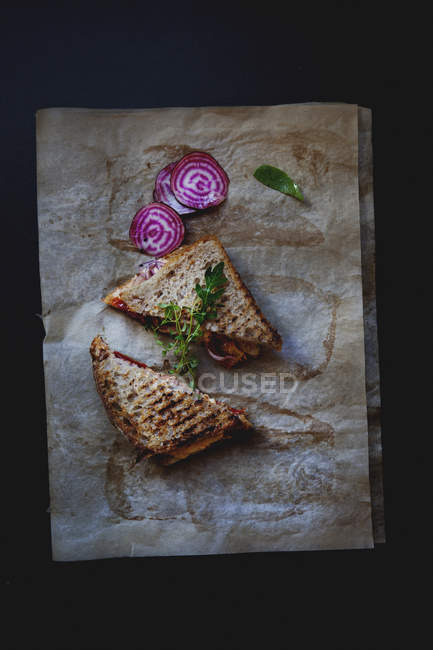 Vista superior de sándwich tostado con remolacha y espinacas - foto de stock