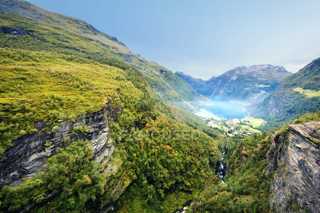Вид на зеленую долину с туманным озером — стоковое фото