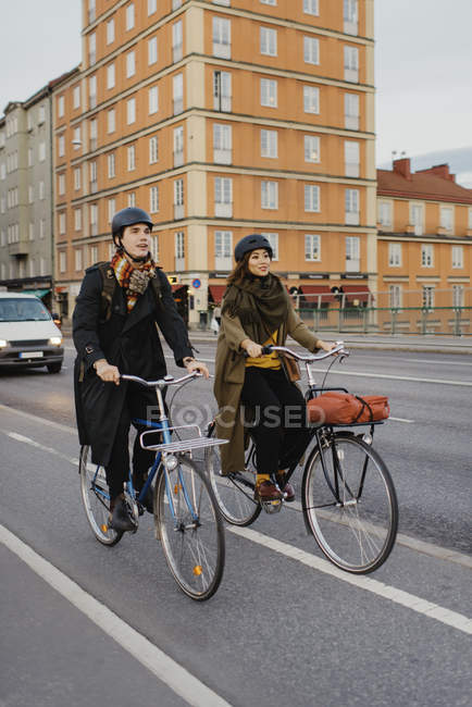 Man and woman cycling on city street, selective focus — Stock Photo