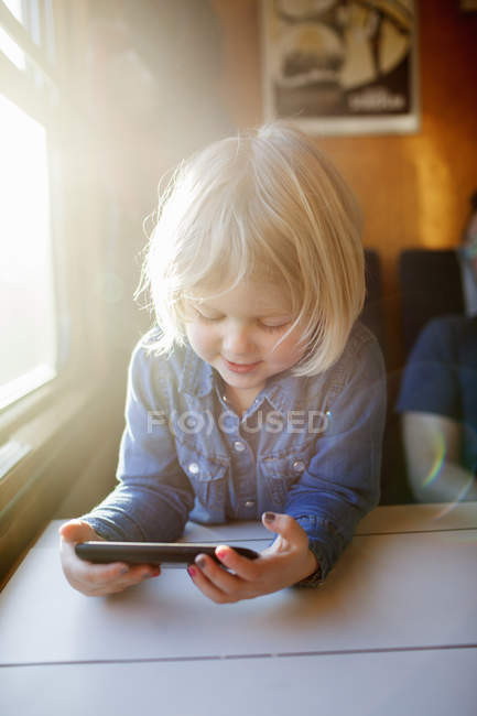 Дівчина використовує смартфон на поїзді, вибірковий фокус — стокове фото