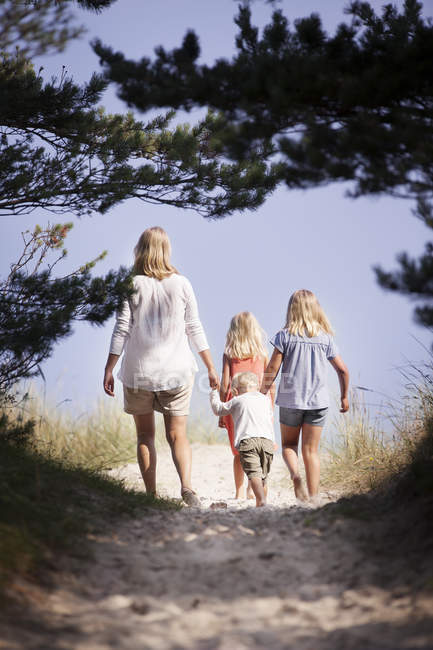 Mother with son and daughters walking along footpath — Stock Photo