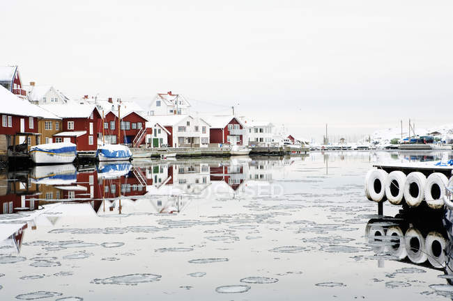 Fishing village houses reflecting in fjord water — Stock Photo