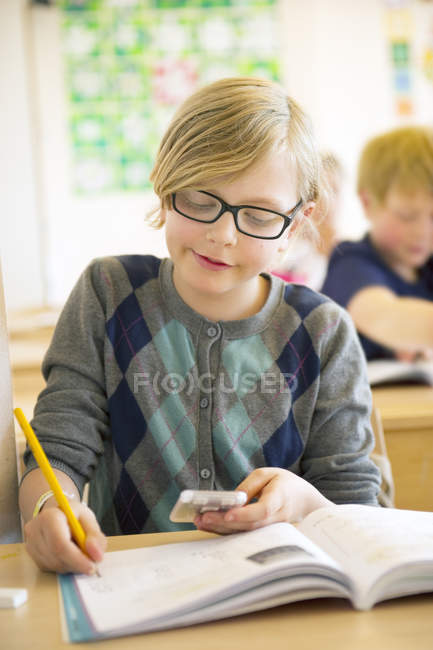 Portrait of schoolgirl writing, focus on foreground — Stock Photo