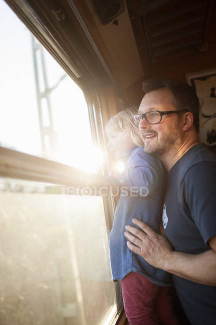 Father and daughter traveling by train, lens flare — Stock Photo
