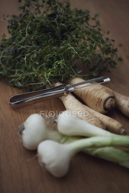 Повышенный вид на травы и овощи на деревянном столе — стоковое фото