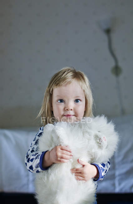 Portrait of girl with toy cat, focus on foreground — Stock Photo