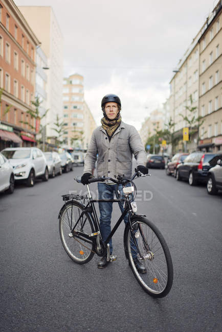 Homem de pé de bicicleta na rua, foco em primeiro plano — Fotografia de Stock