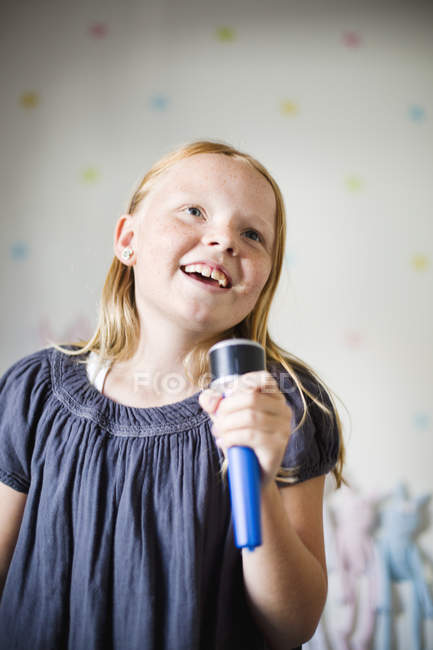 Дівчина співає караоке вдома, вибірковий фокус — стокове фото