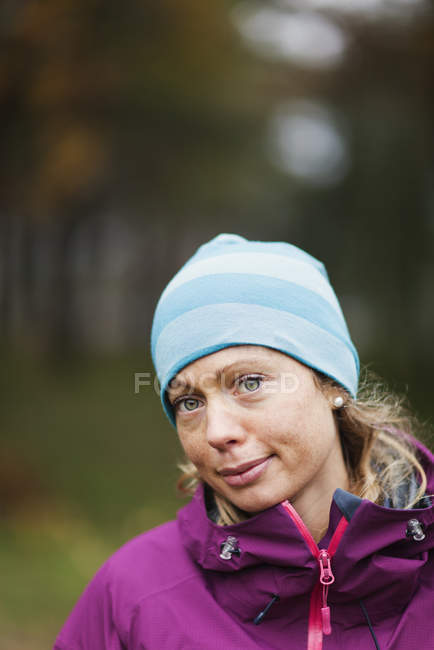 Portrait of mid adult woman wearing warm clothing, focus on foreground — Stock Photo