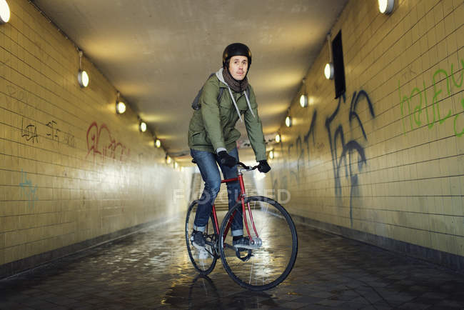 Man riding bicycle through tunnel, selective focus — Stock Photo