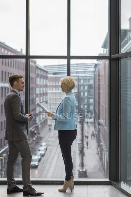 Vista lateral de pessoas de negócios discutindo projeto por janela — Fotografia de Stock