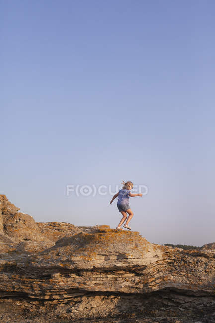 Vue latérale de la fille randonnée sur la formation rocheuse — Photo de stock