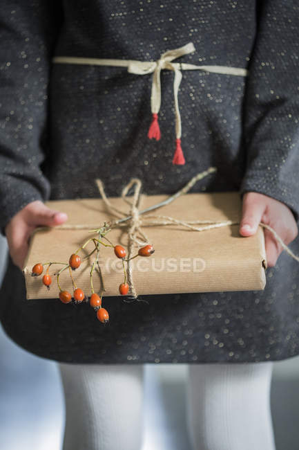 Mittelteil eines Mädchens mit verpacktem Weihnachtsgeschenk — Stockfoto