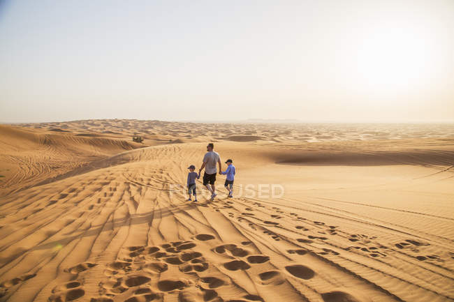 Vater mit Söhnen zu Fuß in der Wüste — Stockfoto