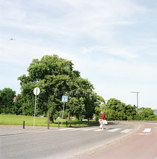 Grandmother and granddaughter crossing street to Kaivopuisto Park — Stock Photo