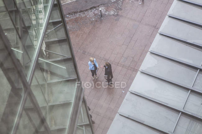 Високий кут зору двох бізнесменів, що стоять біля офісної будівлі — стокове фото