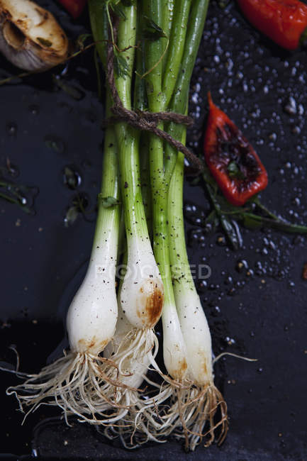 Top view of spring onion with red chili pepper on frying pan — Stock Photo