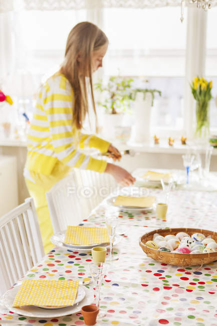 Menina que prepara a mesa para o jantar de Páscoa, foco seletivo — Fotografia de Stock