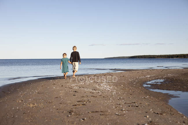 Brother with sister walking along Baltic coast — Stock Photo