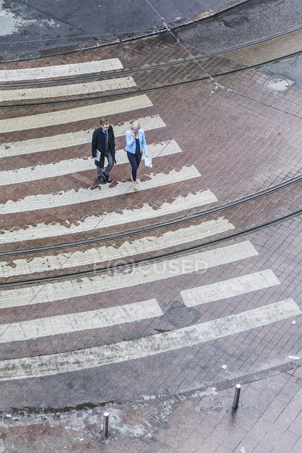 Vista elevada de dos personas cruzando la calle - foto de stock