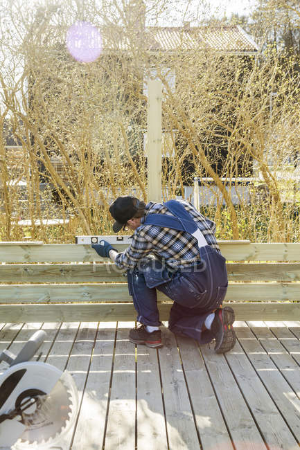 Людина вимірює кут з рівнем на будівельному майданчику — стокове фото