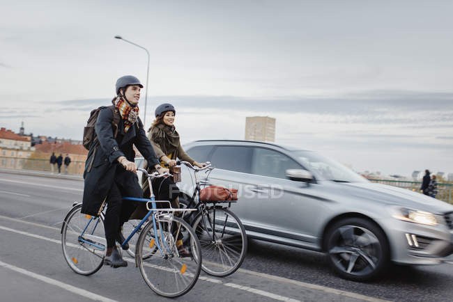 Мужчина и женщина катаются на велосипеде по городской улице, избирательный фокус — стоковое фото
