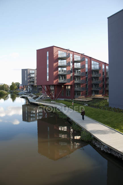 Waterfront condominiums with person on pavement — Stock Photo