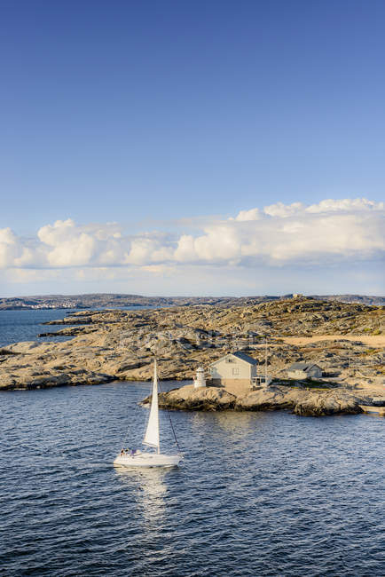 Vista da costa e veleiro na água sob luz solar brilhante — Fotografia de Stock