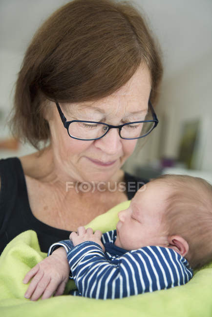 Grandmother with newborn baby girl, focus on foreground — Stock Photo