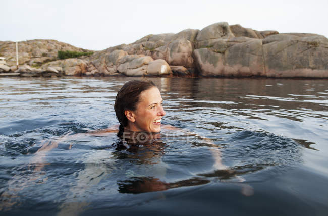 Frau schwimmt im Meer und schaut weg — Stockfoto