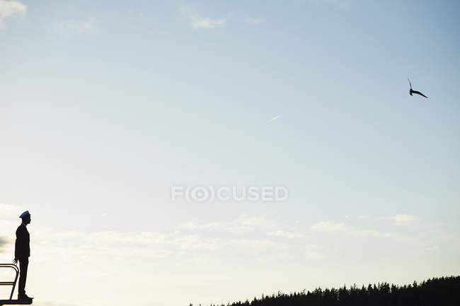 Силуэт человека, смотрящего на миномётную доску, стоящую перед небом — стоковое фото