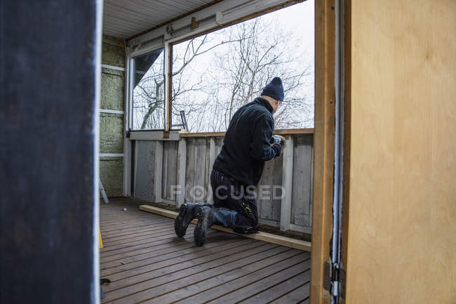 Людина працює над будівництвом дерев'яної балюстради — стокове фото