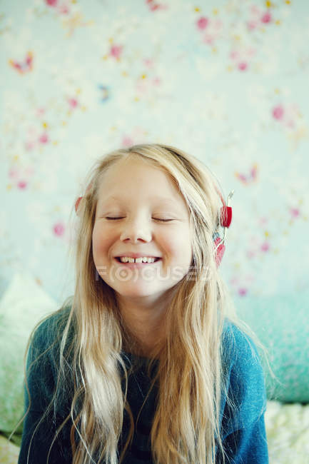 Girl listening to music on headphones, focus on foreground — Stock Photo