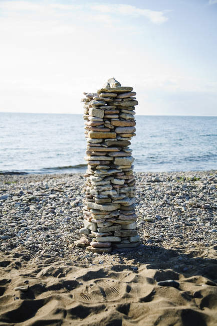 Pile of stones on beach with sea water on background — Stock Photo