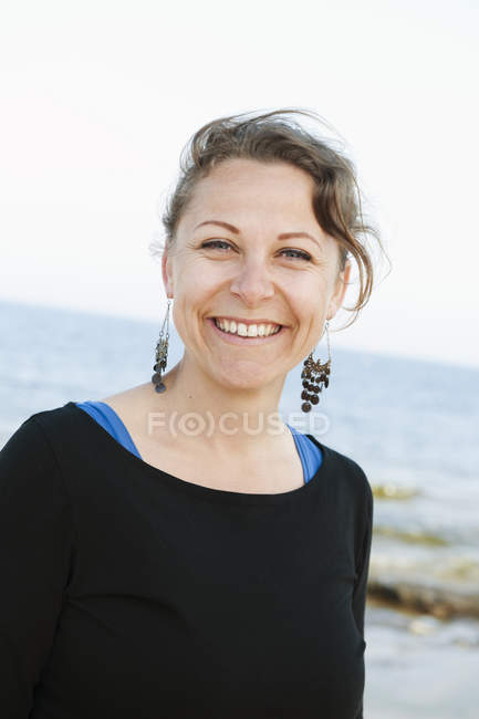 Портрет улыбающейся женщины, море на заднем плане — стоковое фото