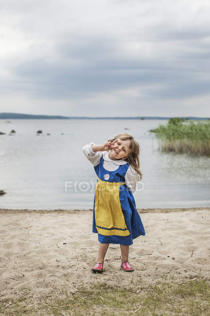 Ragazzina con i capelli biondi sulla riva del lago — Foto stock
