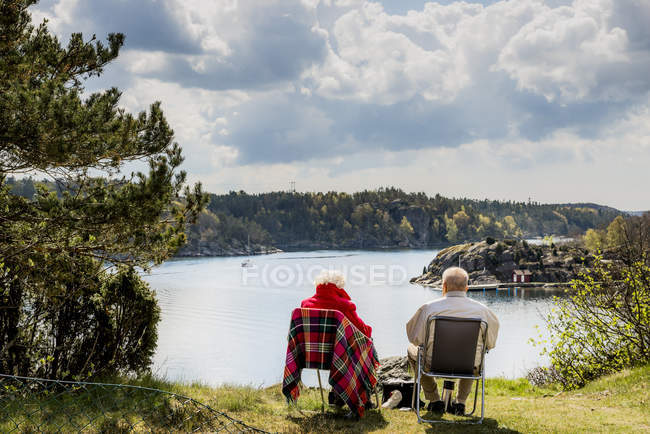 Coppia di anziani seduti su sedie a sdraio e guardando la vista — Foto stock