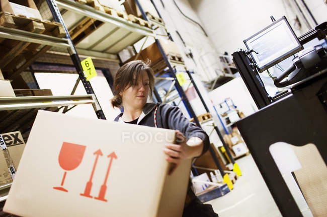 Giovane donna che lavora in magazzino, attenzione differenziale — Foto stock