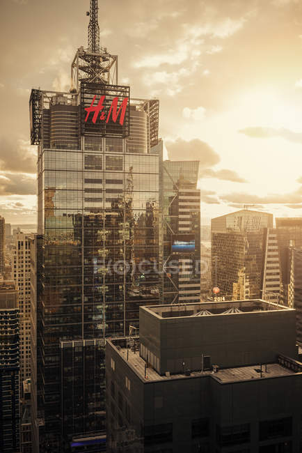 Edificios con cartel comercial en la ciudad de Nueva York al atardecer - foto de stock