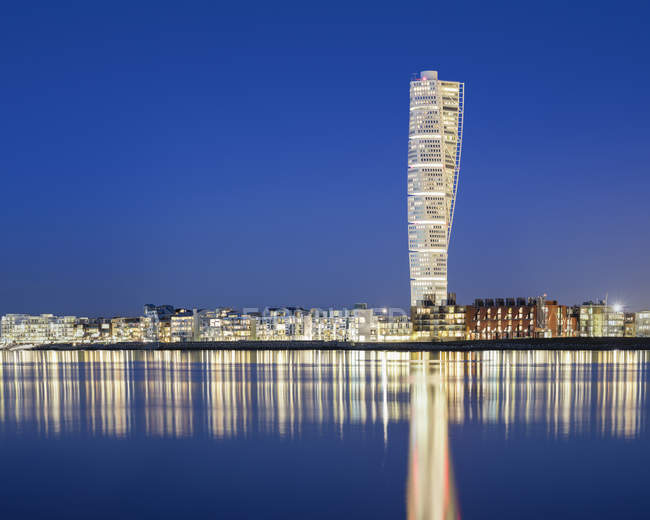 Grattacielo illuminato contro il cielo blu — Foto stock