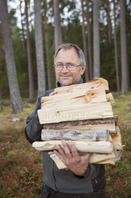 Человек, несущий дрова, дифференцированный фокус — стоковое фото