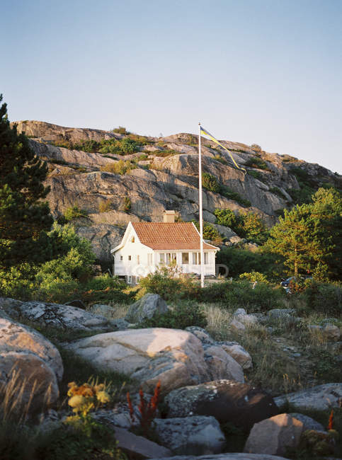 Vista di casa su rocce alla luce del sole di sera — Foto stock