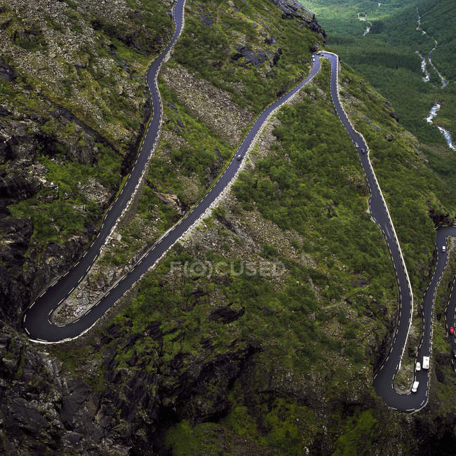 Обернена дорога простягається через зелену гірську долину — стокове фото