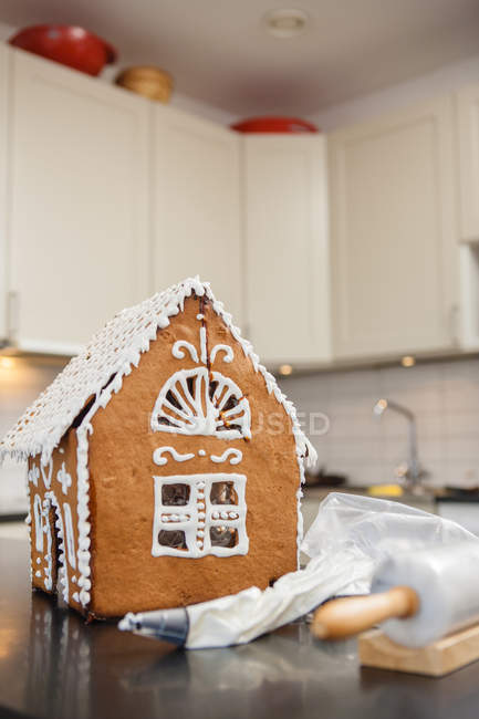 View of gingerbread house with icing bag on kitchen counter — Stock Photo