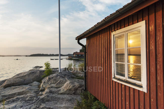 Reflection of sunlight in wooden coastal house window — Stock Photo