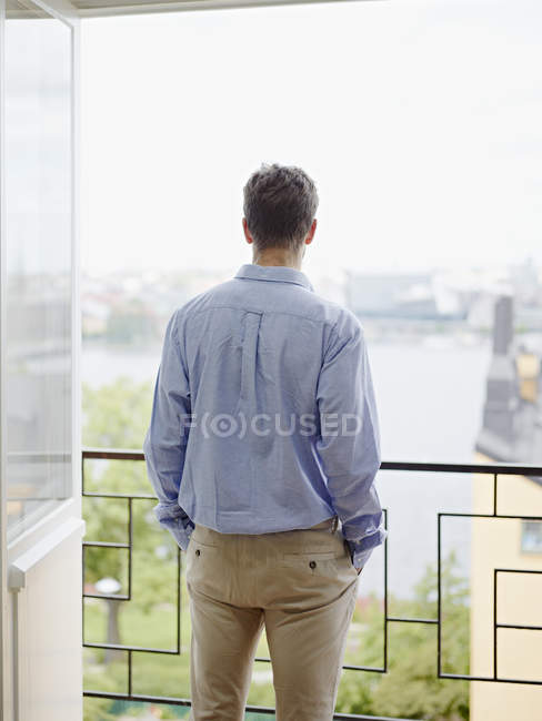 Man looking at view from balcony — Stock Photo