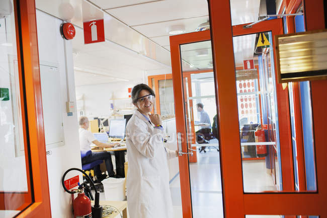 Donna in camice da laboratorio e occhiali protettivi — Foto stock