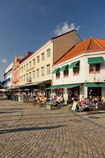 Vue des bâtiments et des personnes dans les restaurants de rue à Lilla Torg — Photo de stock