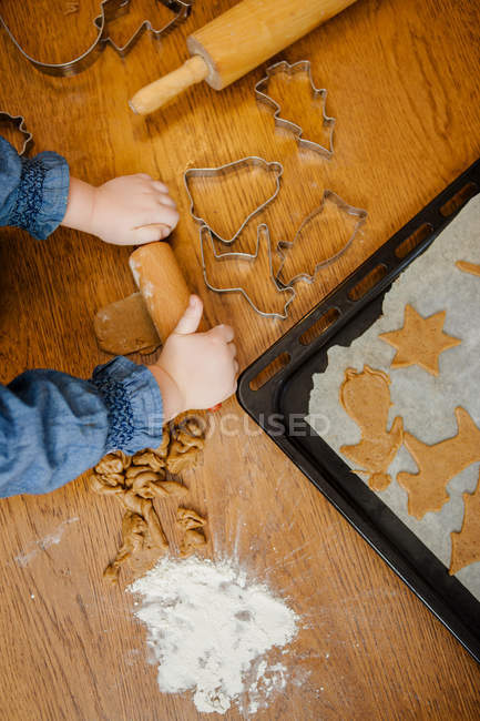Petite fille faire des biscuits sur la table — Photo de stock